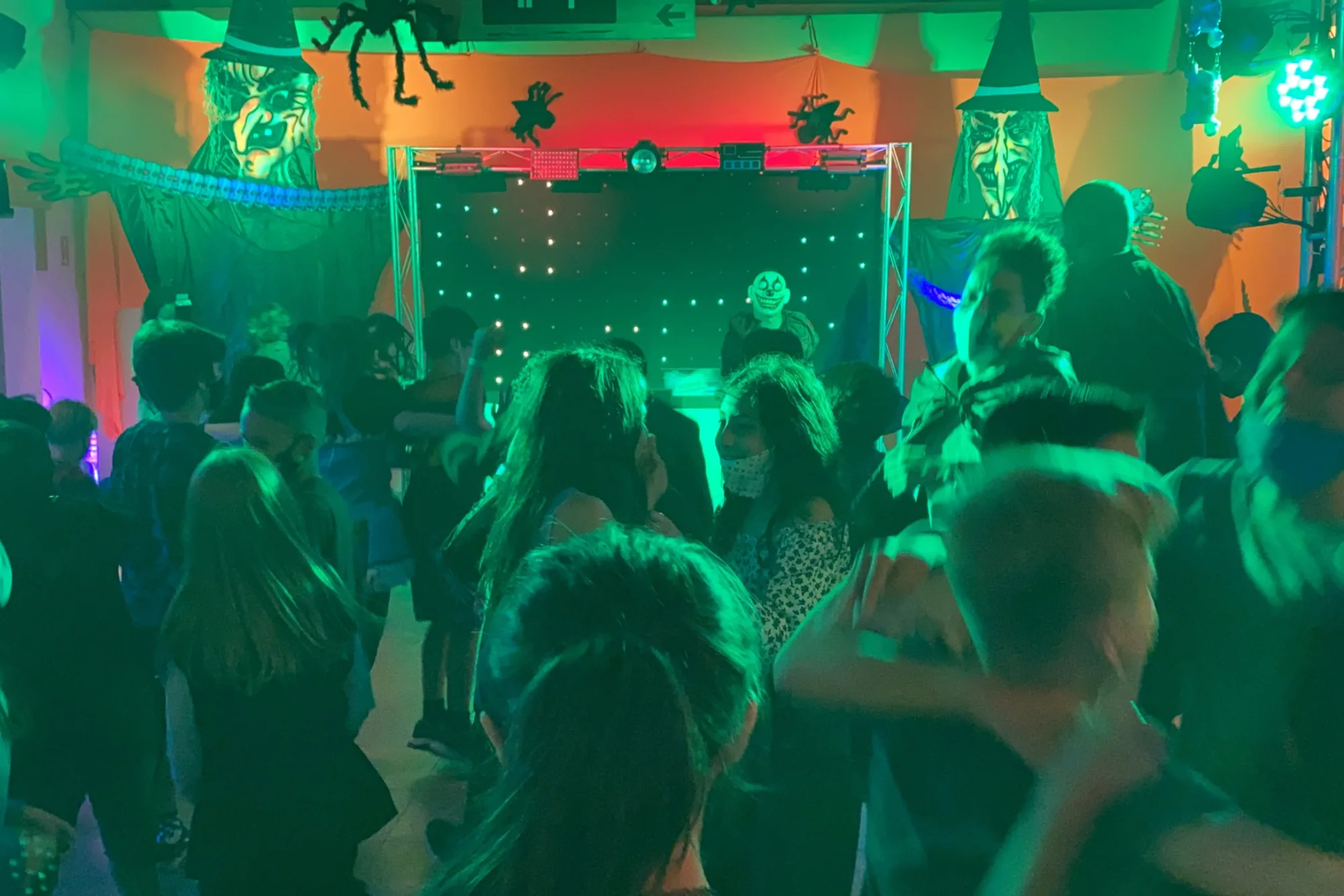 DJ e pista com crianças e adolescentes em festa de Halloween da Balada Animada