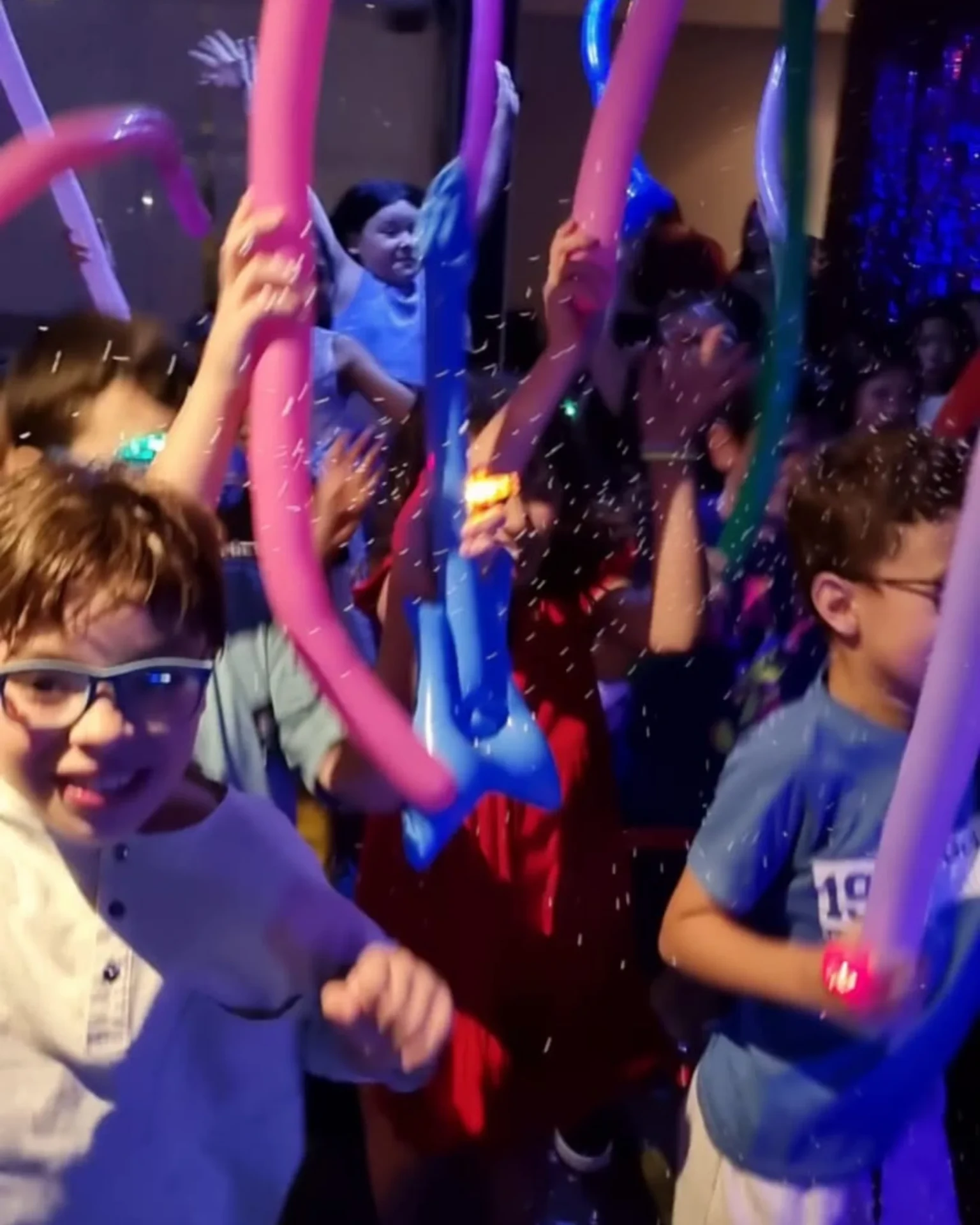 Crianças na pista da Balada Animada com balões coloridos e luzes.