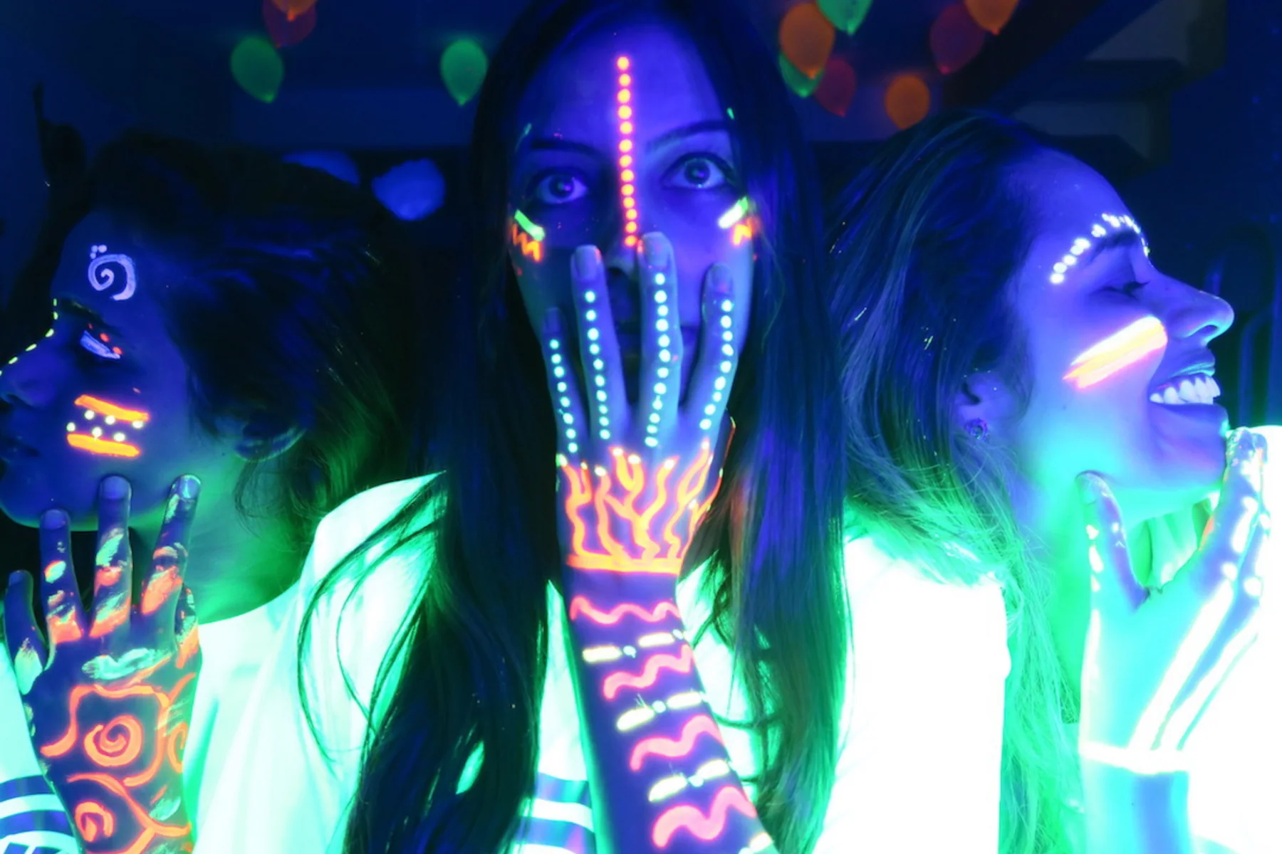 Adolescentes com pintura UV brilhando na festa neon